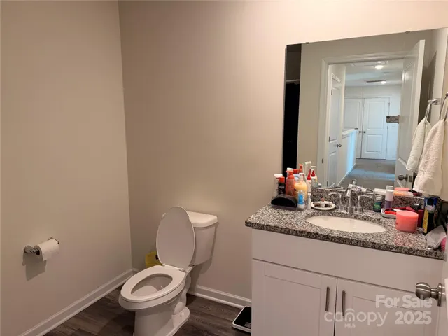 a bathroom with a granite countertop toilet sink and mirror