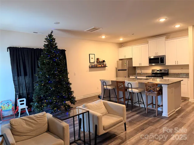 a living room with furniture kitchen view and a potted plant