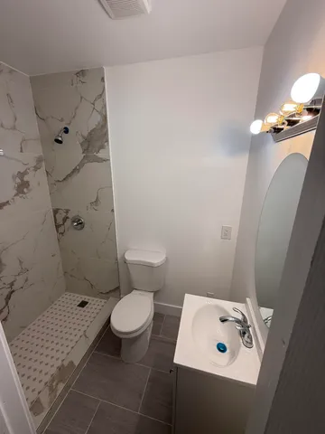 a bathroom with a sink a toilet and shower