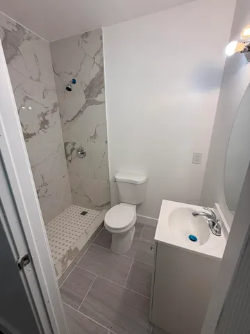 a bathroom with a shower toilet and sink