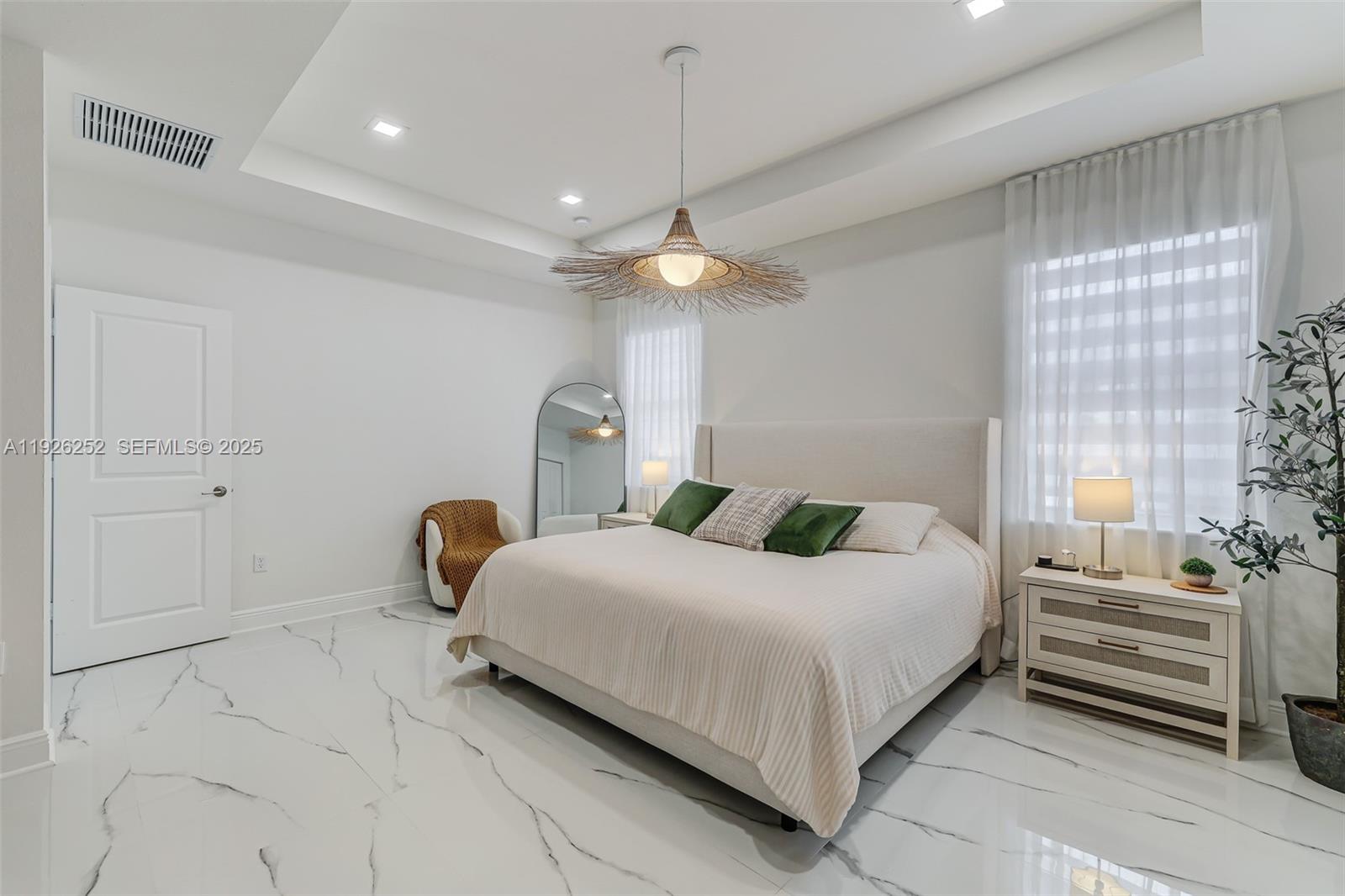 16753 Southwest 290th Street Homestead, FL 33030 - Photo 11 of 29 a bedroom with a bed and a chandelier