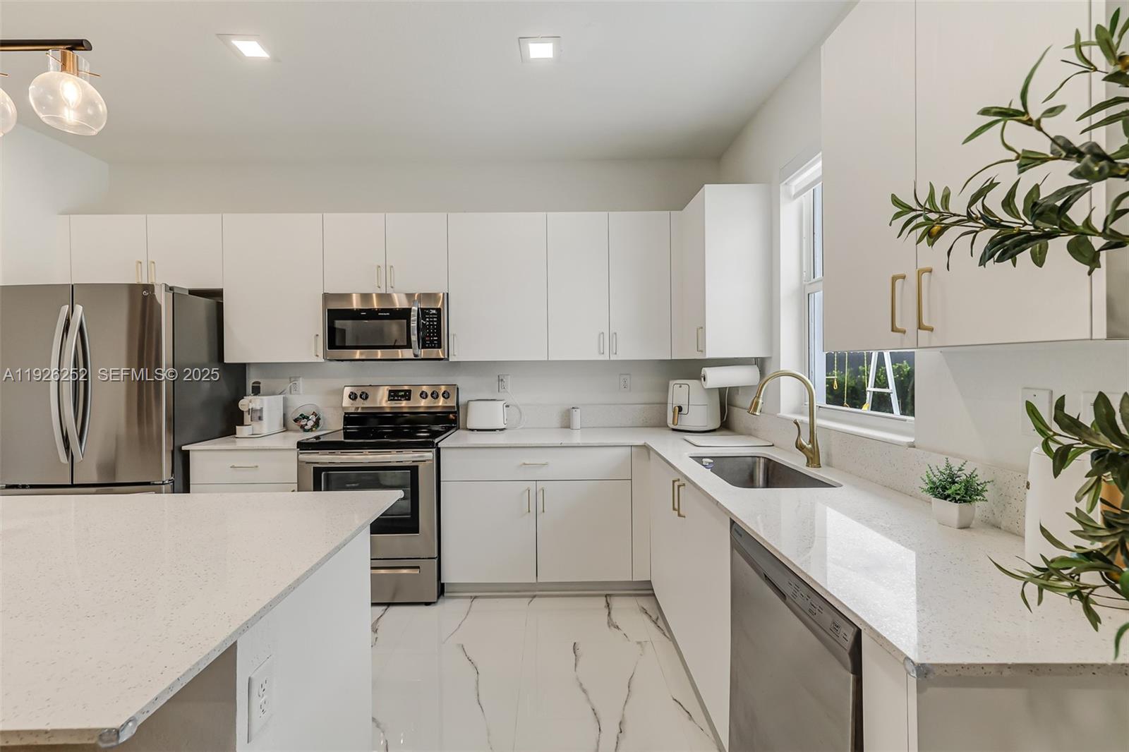 16753 Southwest 290th Street Homestead, FL 33030 - Photo 7 of 29 a kitchen with a sink white cabinets and stainless steel appliances