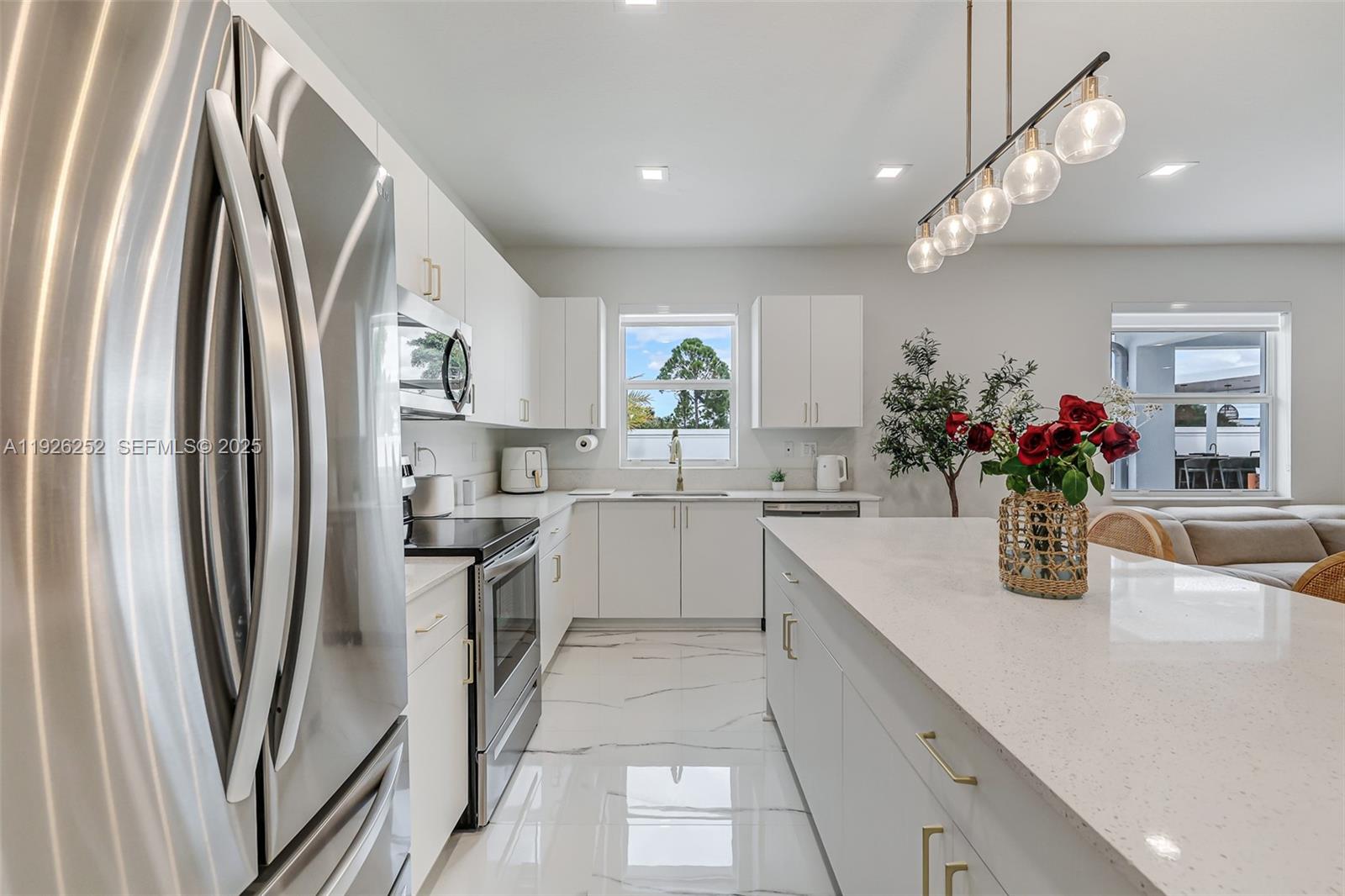 16753 Southwest 290th Street Homestead, FL 33030 - Photo 8 of 29 a kitchen with white cabinets and stainless steel appliances