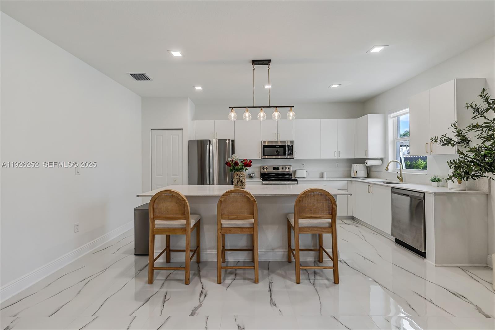 16753 Southwest 290th Street Homestead, FL 33030 - Photo 9 of 29 a kitchen with refrigerator a chair and chairs