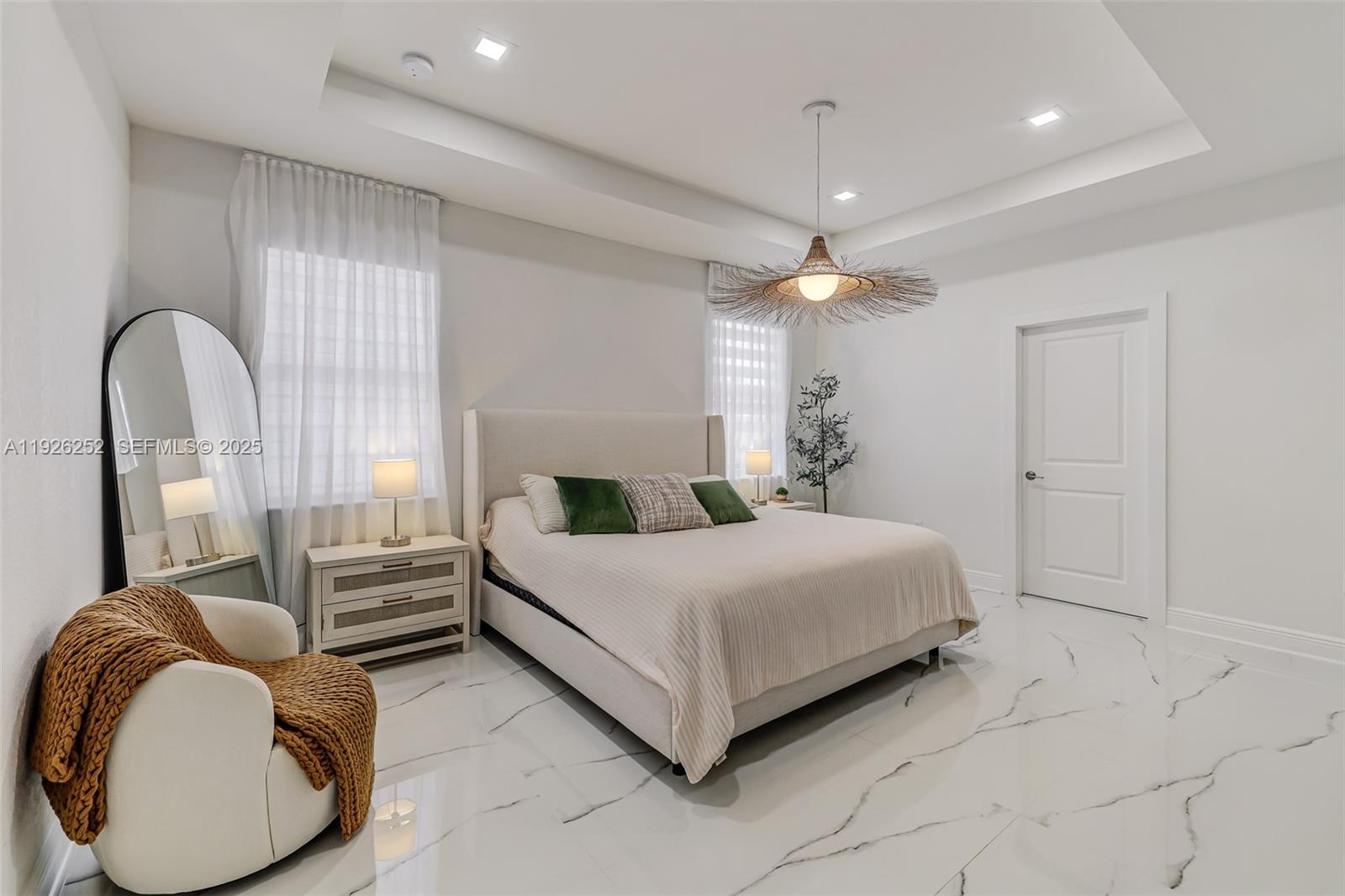 16753 Southwest 290th Street Homestead, FL 33030 - Photo 10 of 29 a spacious bedroom with a bed a chandelier and window