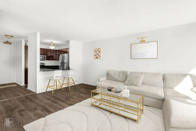 a living room with furniture and kitchen view