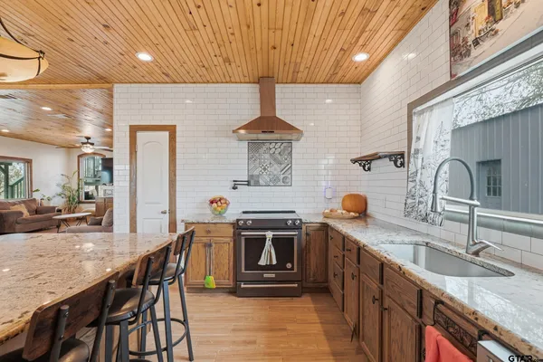 a bathroom with a granite countertop sink a mirror and shower