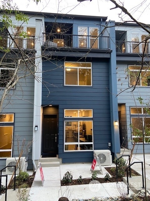8321 Northeast 176th Court, Unit 103 Kenmore, WA 98028 - Photo 1 of 7 a view of a brick house with large windows