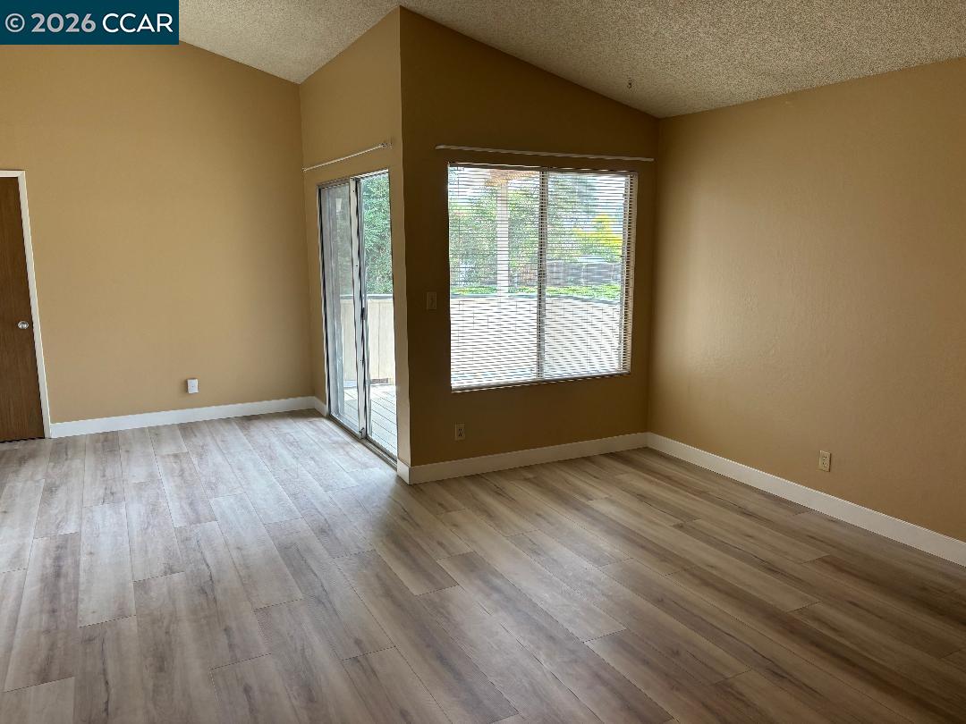 5460 Concord Boulevard, Unit B7 Concord, CA 94521 - Photo 6 of 20 an empty room with wooden floor and windows