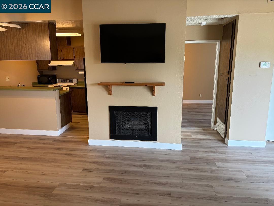 5460 Concord Boulevard, Unit B7 Concord, CA 94521 - Photo 7 of 20 a living room with a fireplace and a flat screen tv