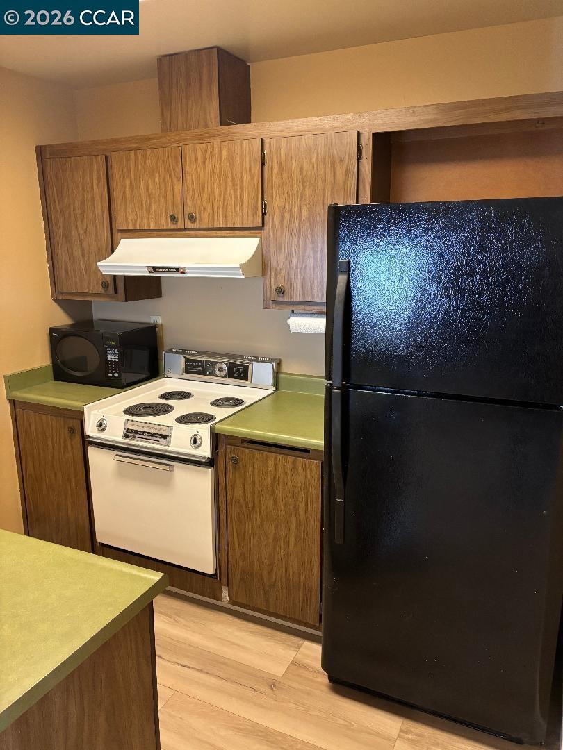 5460 Concord Boulevard, Unit B7 Concord, CA 94521 - Photo 9 of 20 a kitchen with a stove and a refrigerator