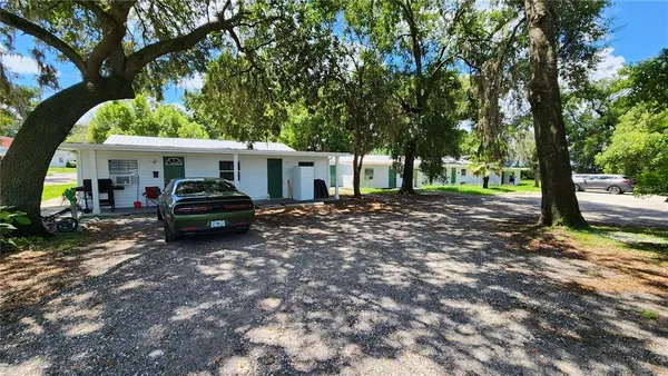 a view of a house with a cars park side of a road