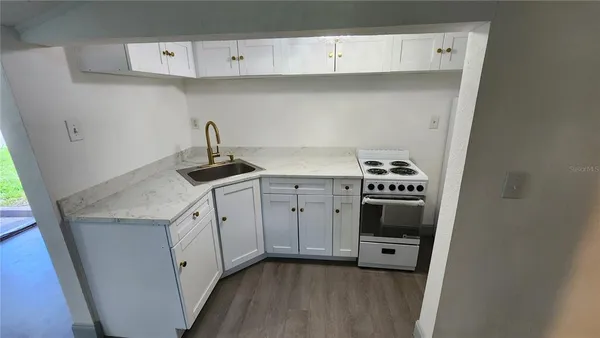 a kitchen with a sink a stove and cabinets