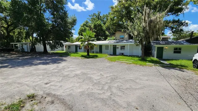 a front view of a house with a yard and trees