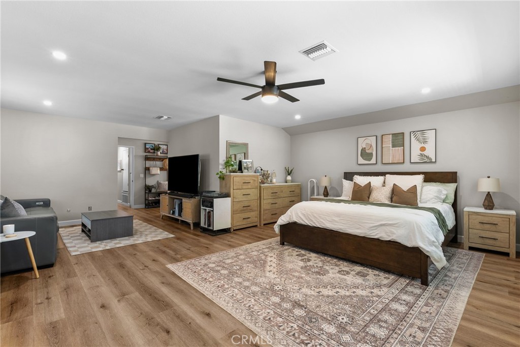 28818 Oak Springs Canyon Road Canyon Country, CA 91387 - Photo 24 of 38 a spacious bedroom with a bed a couch and a flat screen tv