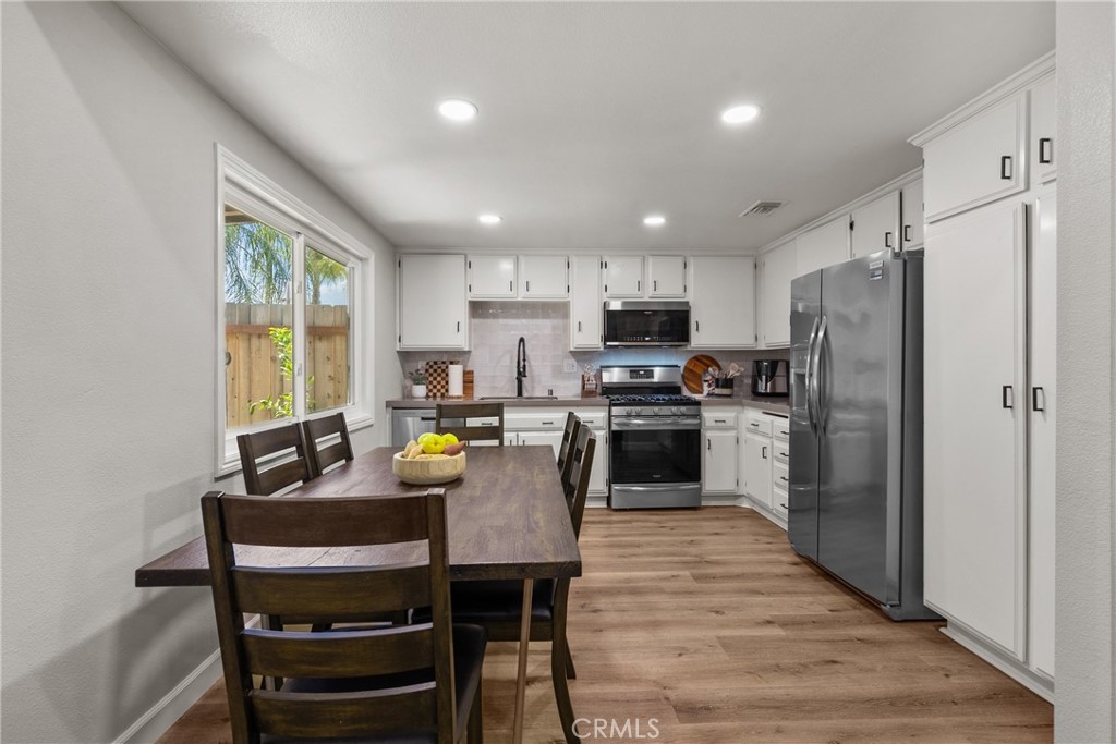 28818 Oak Springs Canyon Road Canyon Country, CA 91387 - Photo 8 of 38 a kitchen with refrigerator cabinets dining table and chairs