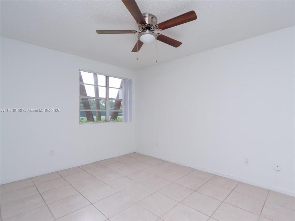 1235 Southwest 46th Avenue, Unit 707 Pompano Beach, FL 33069 - Photo 13 of 15 an empty room with windows and fan