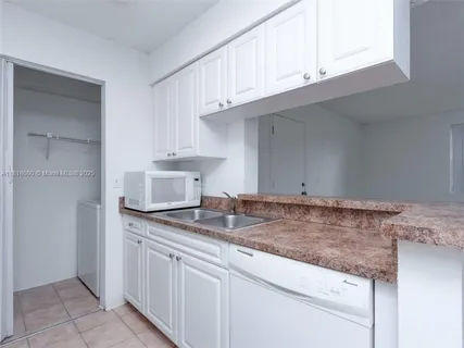 a kitchen with granite countertop a sink and cabinets