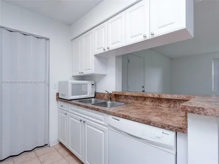 a kitchen with granite countertop cabinets stainless steel appliances and a sink