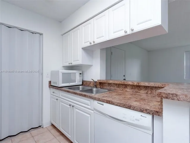 a kitchen with granite countertop cabinets stainless steel appliances and a sink