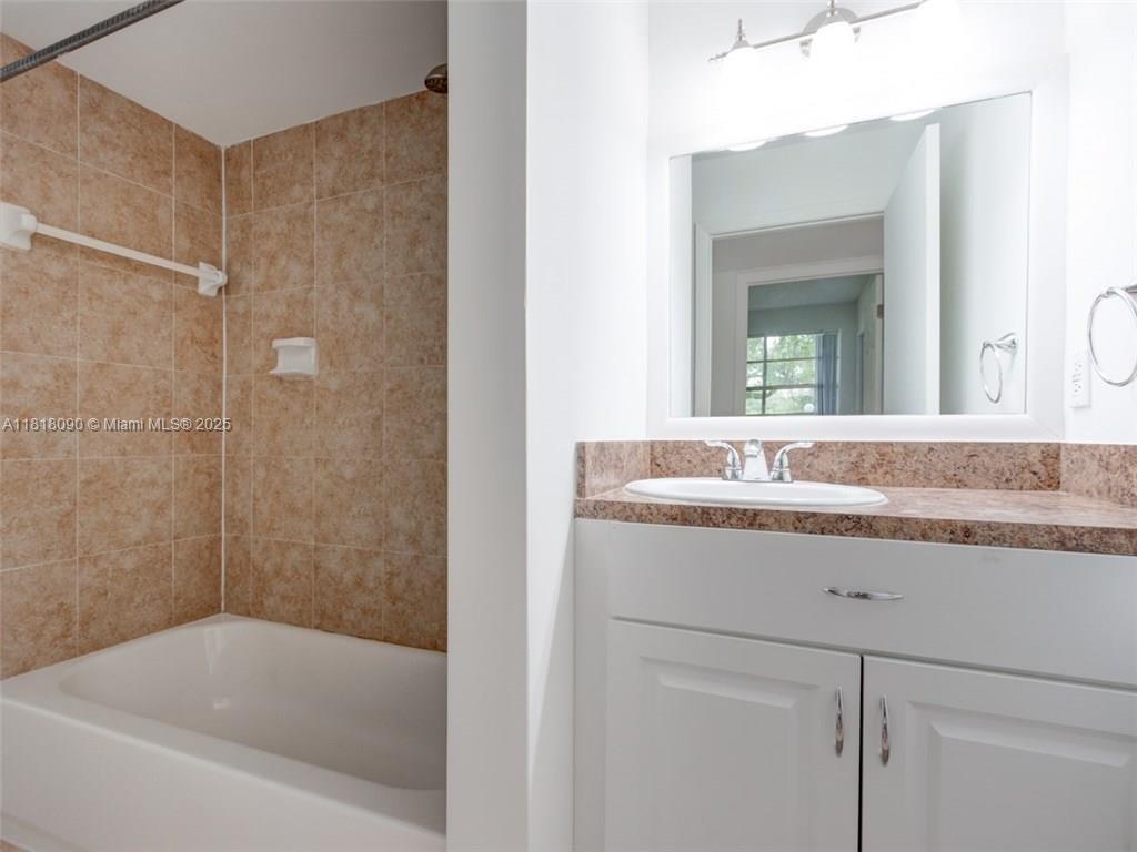1235 Southwest 46th Avenue, Unit 707 Pompano Beach, FL 33069 - Photo 9 of 15 a bathroom with a granite countertop sink mirror and bathtub