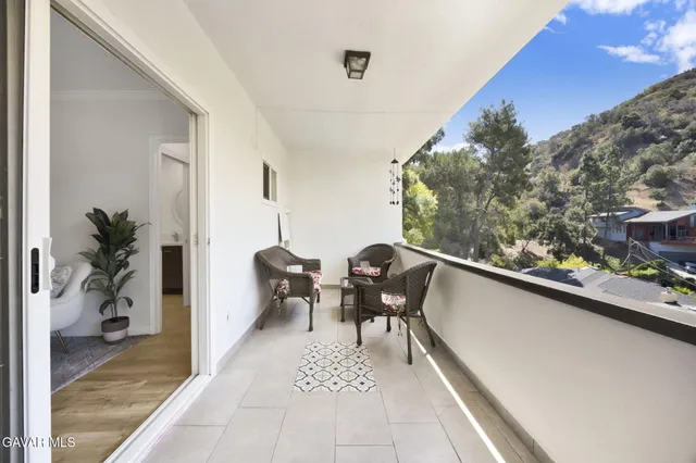 a balcony with furniture and a potted plant