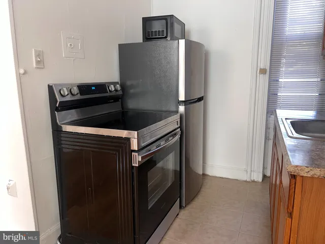 a kitchen with stainless steel appliances granite countertop a stove a refrigerator and a sink