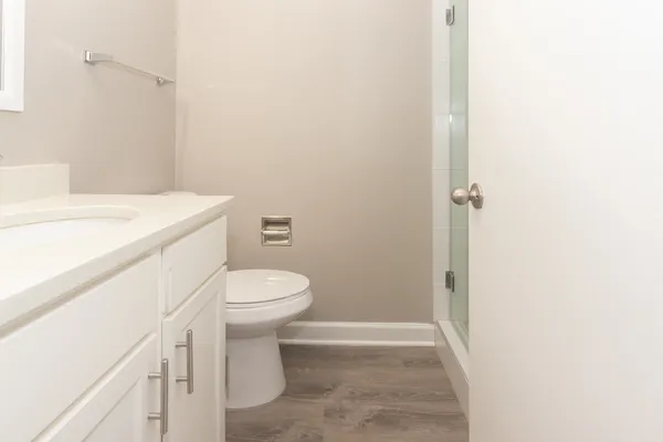 a bathroom with a sink a toilet and shower