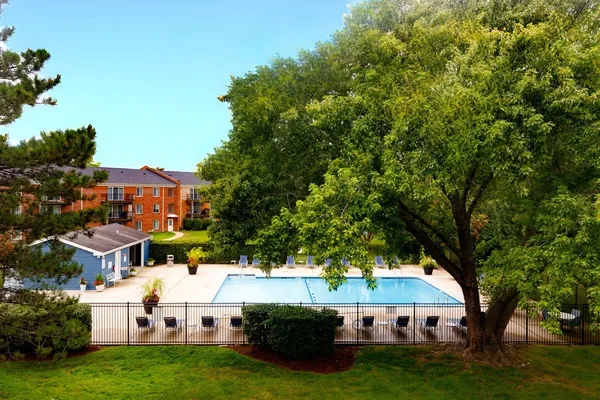 a view of a white house with a big yard and large trees