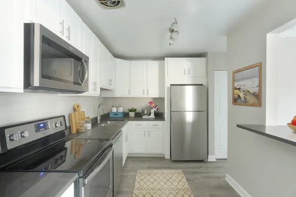 a kitchen with a refrigerator stove and cabinets