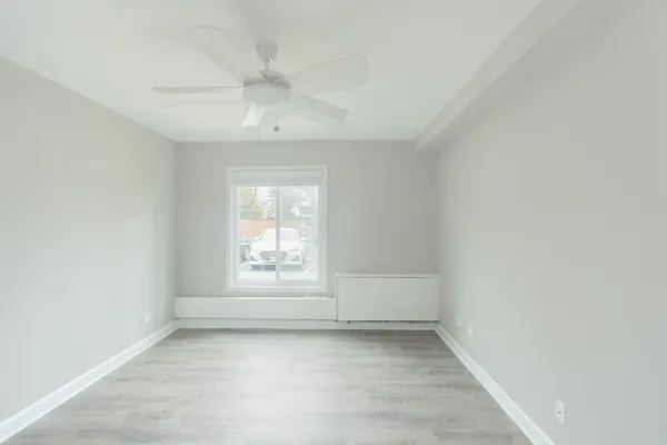 an empty room with a window and fireplace