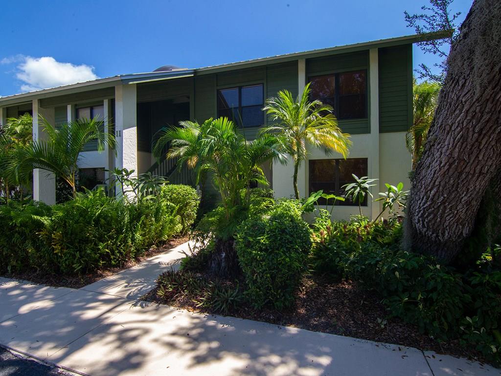 5270 Southeast Seascape Way, Unit 103 Stuart, FL 34997 - Photo 2 of 21 a front view of a house with a yard