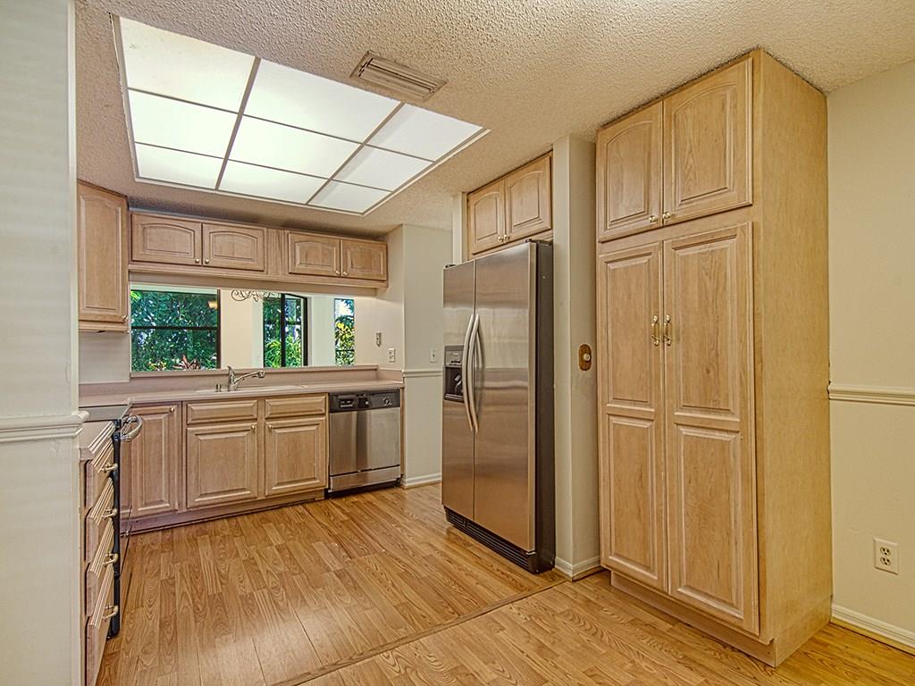 5270 Southeast Seascape Way, Unit 103 Stuart, FL 34997 - Photo 5 of 21 a kitchen with stainless steel appliances granite countertop a refrigerator and window