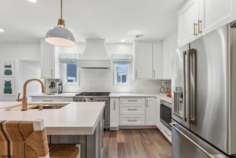 a kitchen with stainless steel appliances granite countertop a stove refrigerator and cabinets
