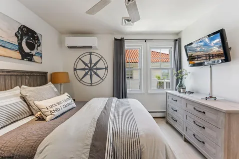 a bedroom with a bed a dresser next to a window