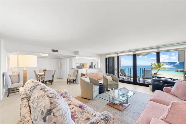 a living room with furniture kitchen view and large windows