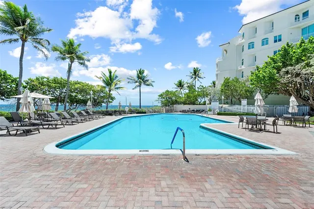 a view of a swimming pool with a patio and plants
