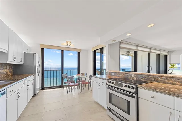 a kitchen with stainless steel appliances granite countertop a stove a sink and a refrigerator