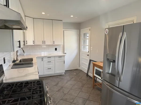 a kitchen with stainless steel appliances a refrigerator sink and stove