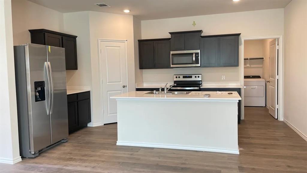 205 Redstone Lane Caddo Mills, TX 75135 - Photo 2 of 5 a kitchen with stainless steel appliances a refrigerator stove and microwave