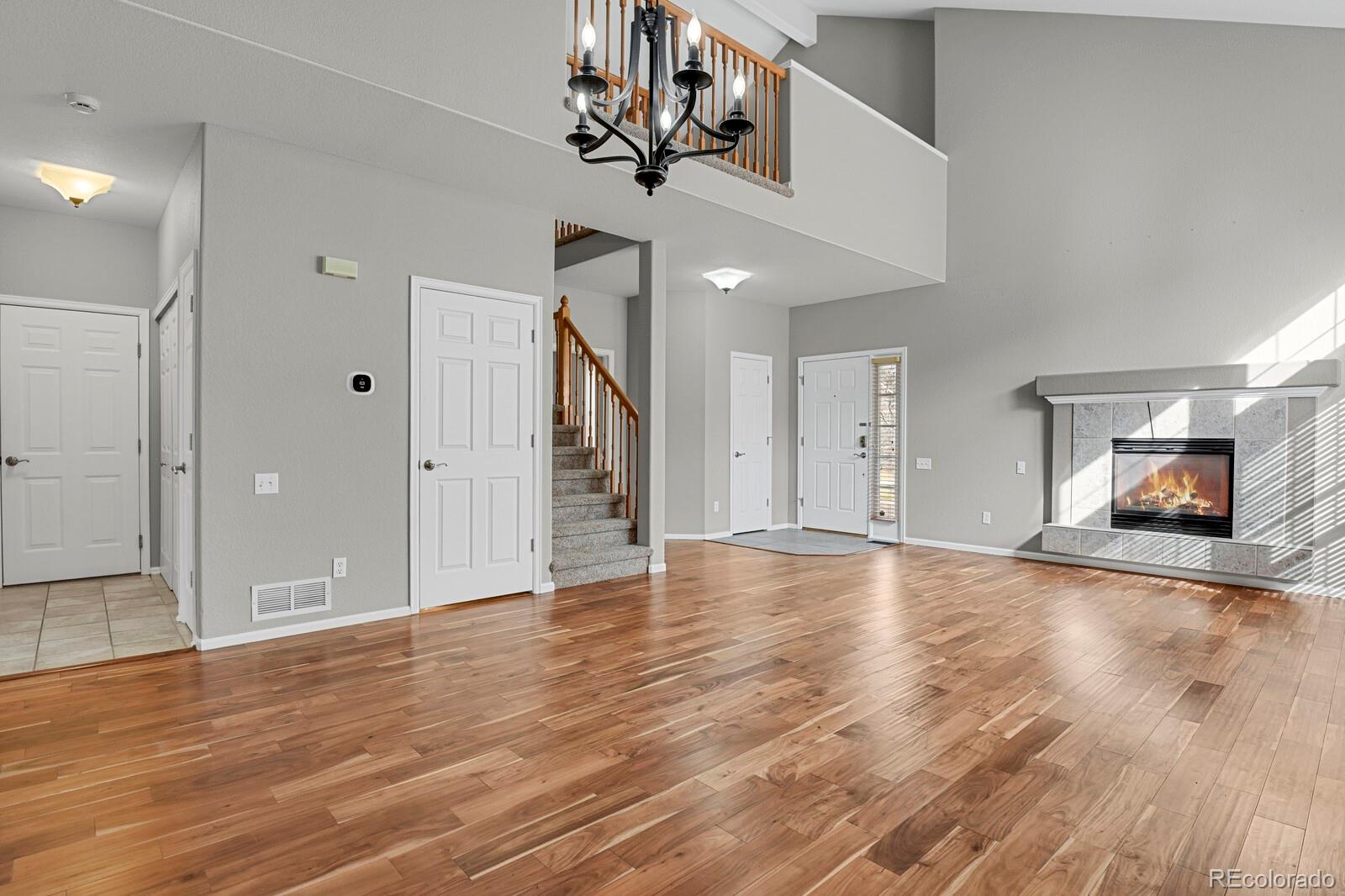 6141 Trailhead Road Highlands Ranch, CO 80130 - Photo 12 of 42 a view of an empty room with wooden floor and a ceiling fan
