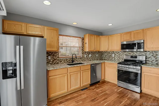 a kitchen with stainless steel appliances granite countertop a refrigerator and a sink