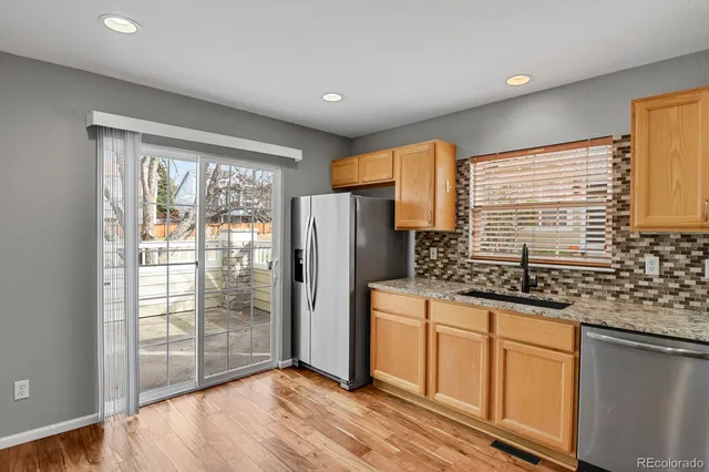 a kitchen with granite countertop white cabinets and stainless steel appliances