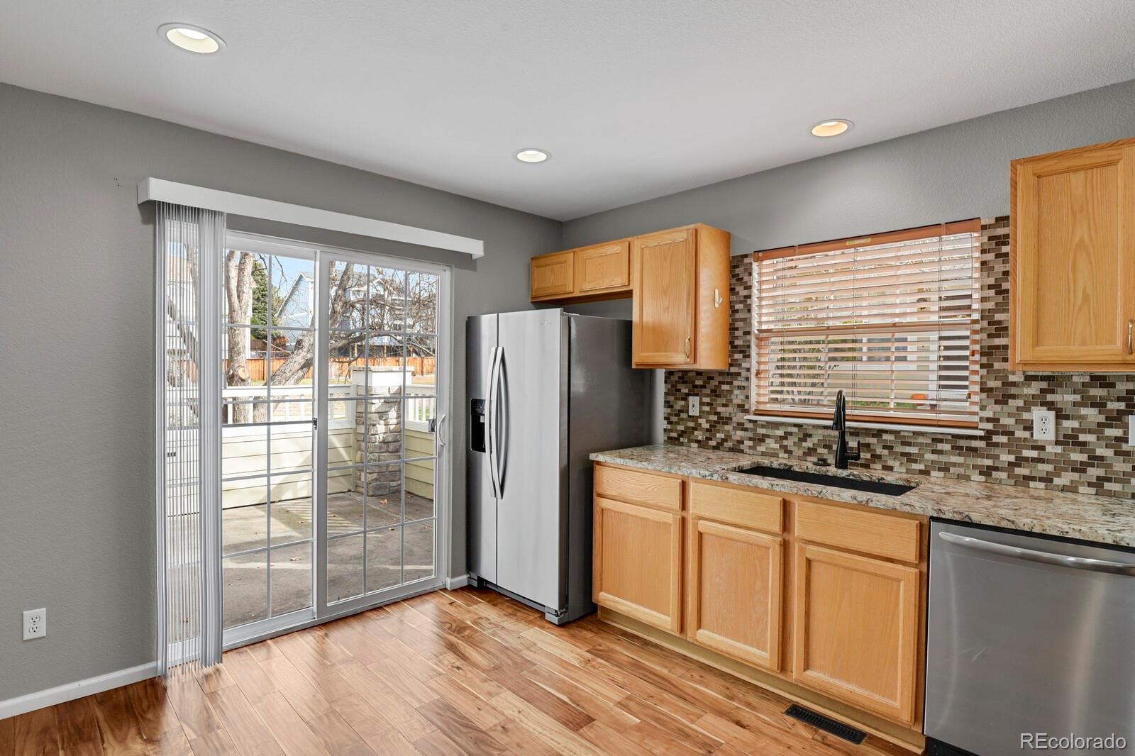 6141 Trailhead Road Highlands Ranch, CO 80130 - Photo 15 of 42 a kitchen with stainless steel appliances granite countertop a refrigerator and a sink