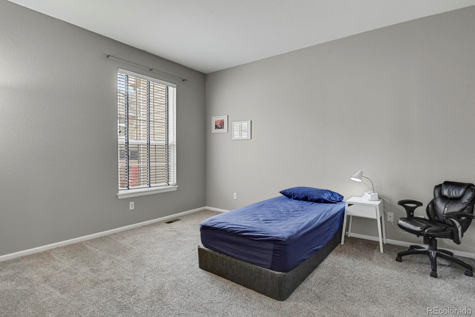6141 Trailhead Road Highlands Ranch, CO 80130 - Photo 22 of 42 a spacious bedroom with a bed and window