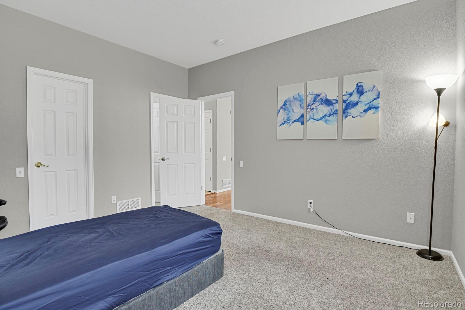 6141 Trailhead Road Highlands Ranch, CO 80130 - Photo 23 of 42 a bedroom with a bed and painting on the wall