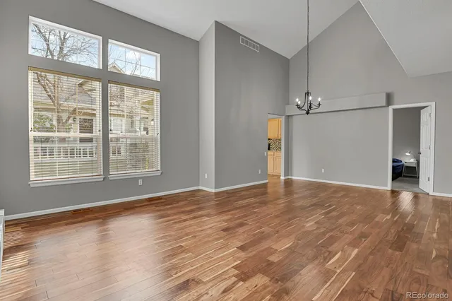 a view of an empty room with wooden floor and entryway
