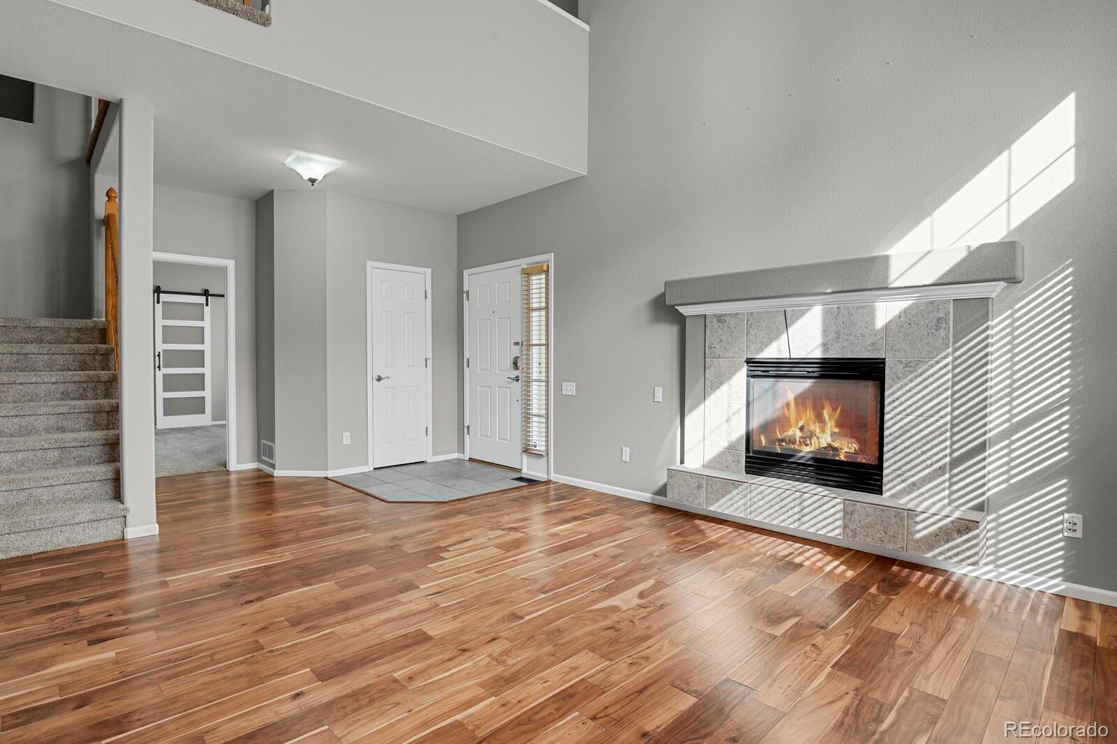 6141 Trailhead Road Highlands Ranch, CO 80130 - Photo 8 of 42 a view of a room with wooden floor a fireplace and window