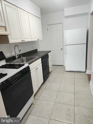 a kitchen with a stove a refrigerator and a sink