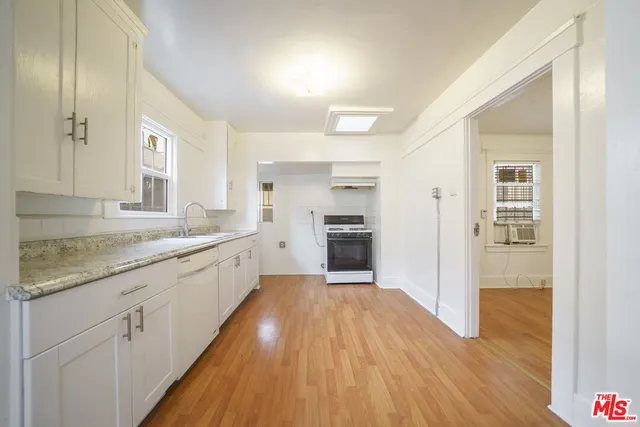 a large kitchen with granite countertop a large counter top space and stainless steel appliances